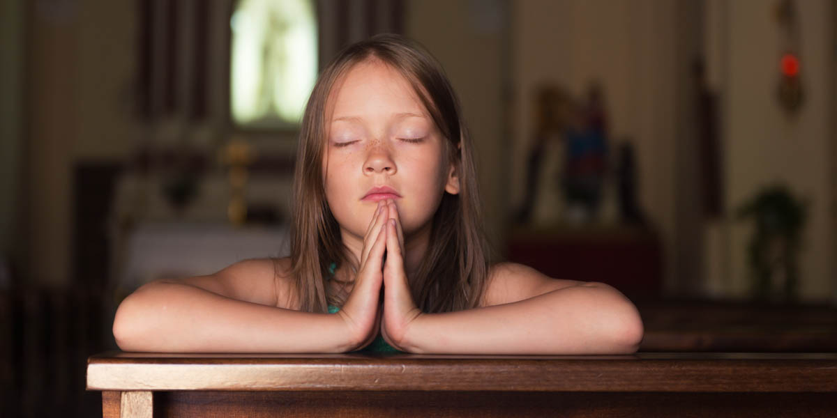 CHILD PRAYING IN PEW